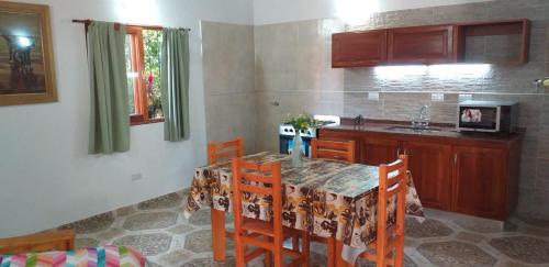 a kitchen with a table and chairs and a kitchen with a sink at LAS MACLURAS in Mar de Ajó