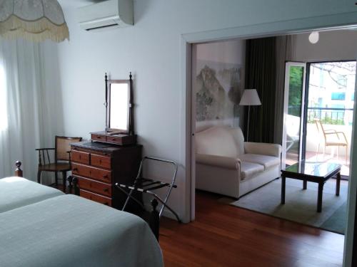 a bedroom with a bed and a mirror and a couch at Vila Vicência in Funchal