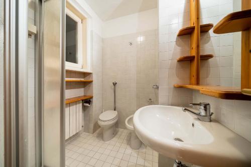 a white bathroom with a sink and a toilet at Villa Radiosa - Stayincortina in Cortina dʼAmpezzo