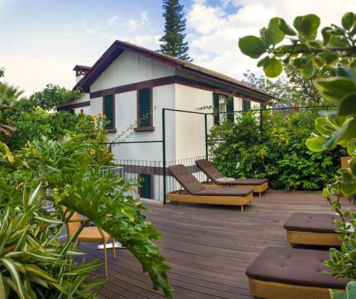 a deck with chairs and a house in the background at Vila Vicência in Funchal