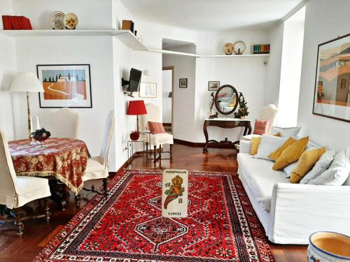 un soggiorno con divano bianco e tappeto rosso di Casa Vacanze Pizzofalcone 41b a Napoli