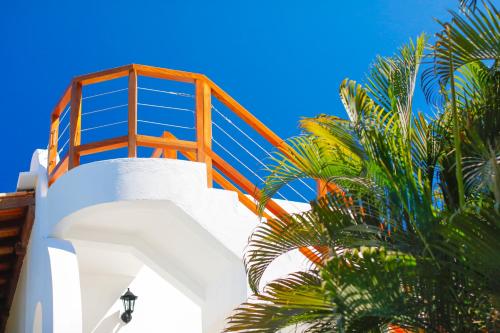 a staircase leading up to a building with palm trees at Encanto das Flores in Pipa