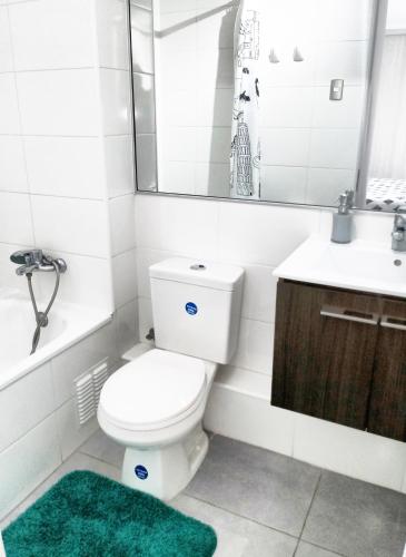 a bathroom with a toilet and a sink and a mirror at Vista Chinchorro in Arica