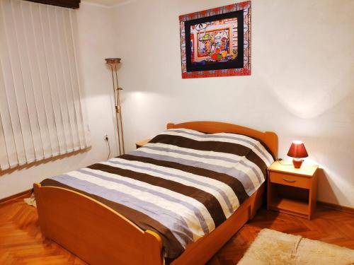 een bed in een kamer met een lamp en een foto aan de muur bij V2 with Love - Vintage Modern and Spacious in Belgrado