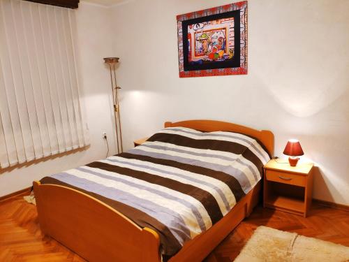 a bed in a room with a lamp and a picture on the wall at V2 with Love - Vintage Modern and Spacious in Belgrade