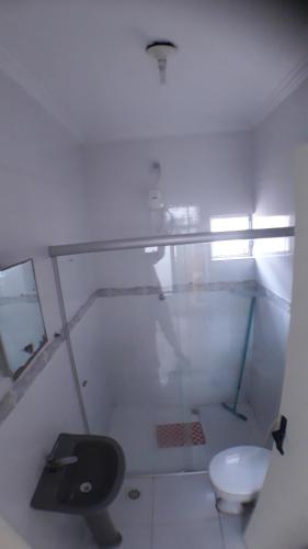 a white bathroom with a toilet and a window at CASA DE TEMPORADA in Aracaju