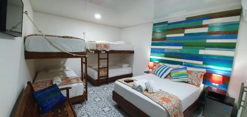 een slaapkamer met 2 stapelbedden en een kleurrijke muur bij Olas Del Caribe in San Andrés