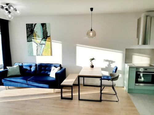 a living room with a blue couch and a table at Jacuzzi Apartamenty Gdańsk - RELAX Apartments in Gdańsk