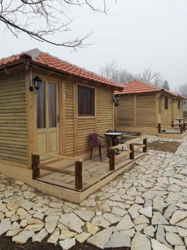a log cabin with a deck and a table at Brvnare Rodjak sa sela in Mionica