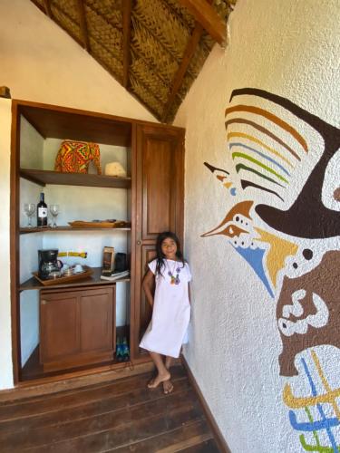 a young girl standing in a room with a wall at Reserva Natural Tierra Adentro in Minca
