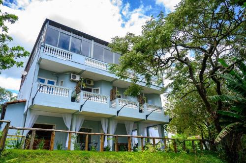 un edificio blu con balconi e alberi di Feliccità Pousada a Extrema