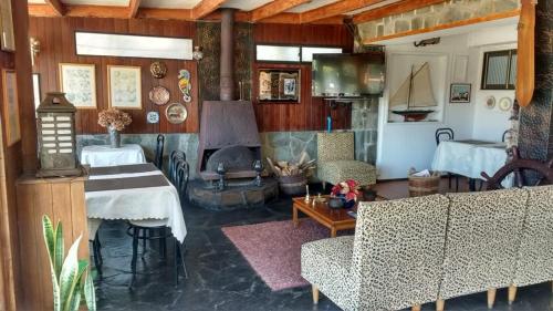 a living room with a fireplace and a couch and a table at Hotel y Cabañas La Rosa Nautica in Pichidangui