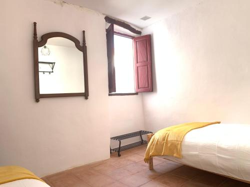 a bedroom with a bed and a mirror on the wall at Tinao de Las Alcántaras in Lanjarón