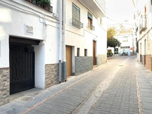 an empty alley with a building and a gate at Tinao de Las Alcántaras in Lanjarón