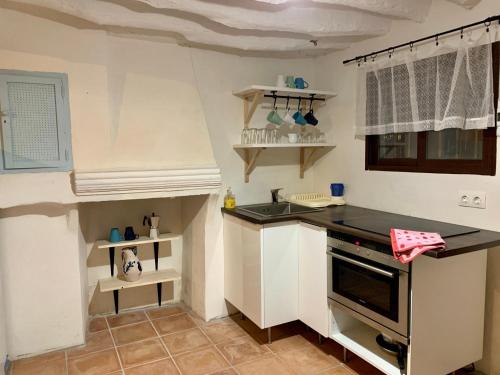 a small kitchen with a sink and a stove at Tinao de Las Alcántaras in Lanjarón