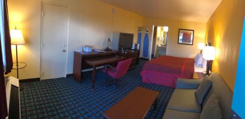 a hotel room with a bedroom with a desk and a bed at Days Inn by Wyndham Santa Fe New Mexico in Santa Fe