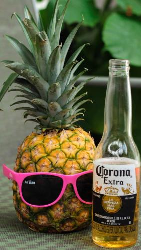 a pineapple with sunglasses and a bottle of corona extra at La Vaina Cali in Cali