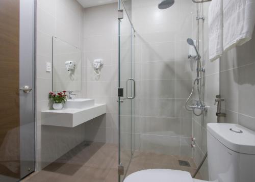 een badkamer met een douche, een toilet en een wastafel bij PIANO HOTEL in Ho Chi Minh-stad