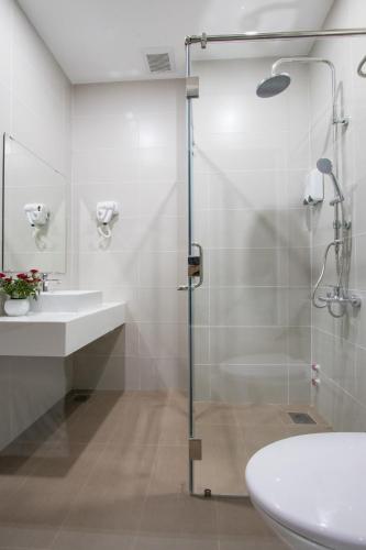 a bathroom with a shower and a toilet and a sink at PIANO HOTEL in Ho Chi Minh City