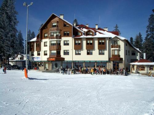 a large building with a group of people in the snow at Ice Angels Hotel in Borovets