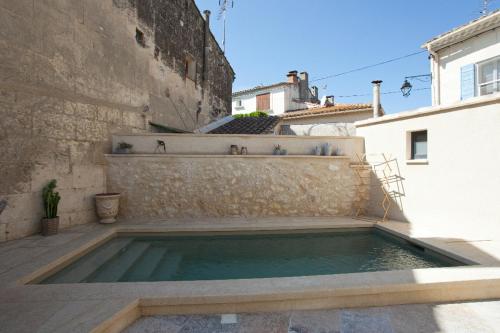 une piscine dans la cour d'un immeuble dans l'établissement Maison de village provencal avec piscine, à Fontvieille
