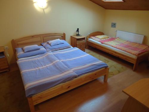 two twin beds in a room with at Czermann Panzió és Étterem in Oroszlány