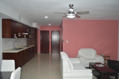 a living room with white furniture and a red wall at Residences Sommet Port Salut in Port-Salut