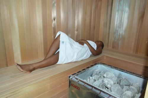 a man laying in a sauna with his head in a towel at Residences Sommet Port Salut in Port-Salut