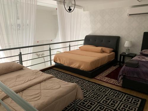 a bedroom with two beds next to a window at Kyra Luxury Duplex Studio @ Pinnacle Kelana Jaya in Kampong Baharu Sungai Way