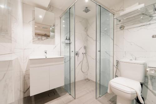 a bathroom with a toilet and a glass shower at Heritage Collection on Chinatown - Mobile App Check-In in Singapore