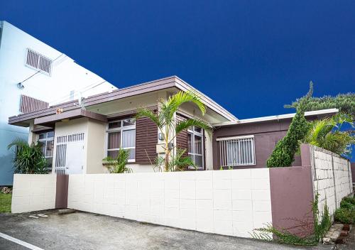a house with a fence in front of it at カビラハウス Kabira House 窓から見える川平湾まで徒歩1分 in Ishigaki Island