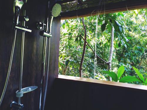 - une fenêtre dans une chambre avec vue sur la forêt dans l'établissement Tree House-Midigama, à Weligama