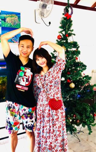 a boy and a girl standing in front of a christmas tree at White Villa Airport Transit Hotel in Katunayake