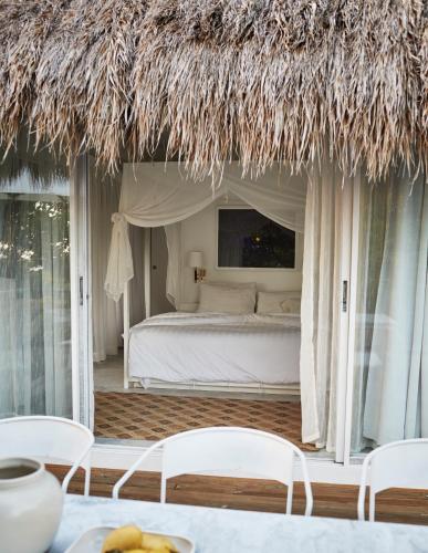 a bedroom with a bed and a thatch roof at Diniview Villa Resort in Boracay