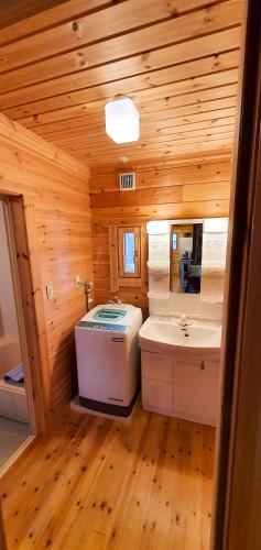 a bathroom with a toilet and a sink in a cabin at Hakuba Powder Cottage Deep in Hakuba