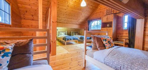 a bedroom with two bunk beds in a log cabin at Hakuba Powder Cottage Deep in Hakuba