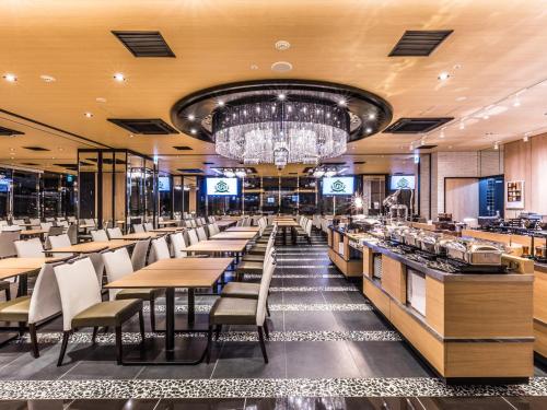 a restaurant with tables and chairs and a chandelier at APA Hotel & Resort Midosuji Hommachi Eki Tower in Osaka