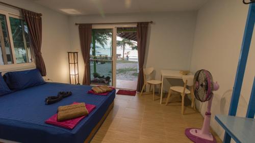 a bedroom with a blue bed and a table and a table at Phayam Friends in Ko Phayam