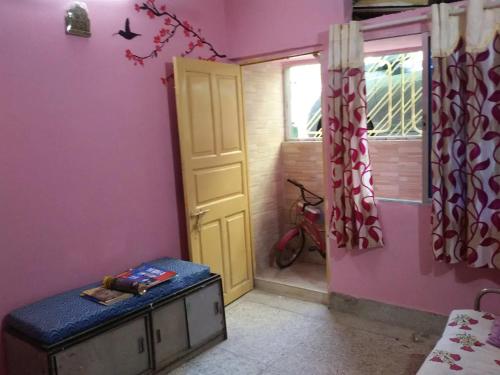 um quarto com uma cama, uma porta e uma janela em Pushpa Di Ghar em Calcutá