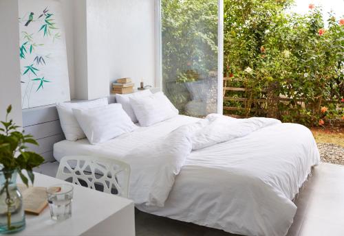 a bed with white sheets and pillows in a room at Diniview Villa Resort in Boracay