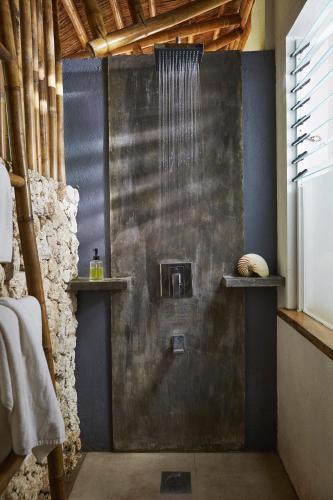 a bathroom with a shower with a metal wall at Diniview Villa Resort in Boracay