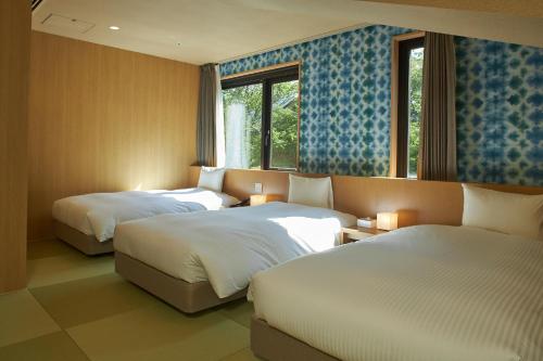 a hotel room with two beds and a window at Hakone Yutowa in Hakone