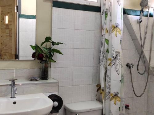 a bathroom with a shower curtain with a toilet and a sink at Aunt & Uncle's House in Chiang Mai