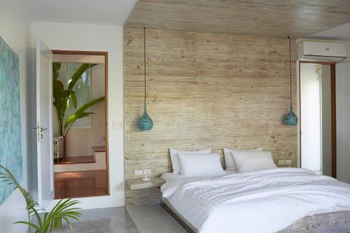 a bedroom with a white bed with a wooden wall at Diniview Villa Resort in Boracay