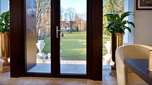 a glass door with a view of a yard at Zámek Wichterle - Hotel a pivní lázně in Slavičín