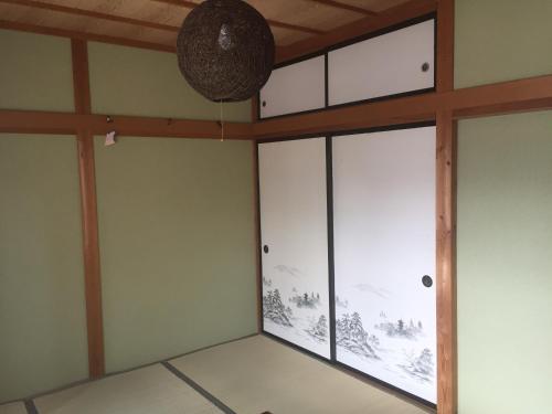 a room with glass doors and a ceiling at Guest house daisho oshiro asobi in Matsue