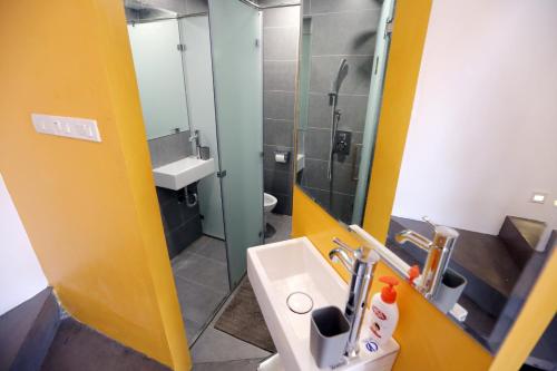 a bathroom with a sink and a glass shower at Hanoi Banana Hostel in Hanoi