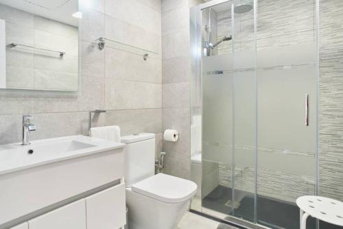 a bathroom with a toilet and a glass shower at Pure Pool Sensation Apartment Sitges in Sitges
