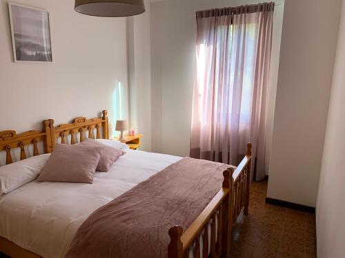 - une chambre avec un grand lit et une fenêtre dans l'établissement Bilocale Sorgente, à Ponte di Legno