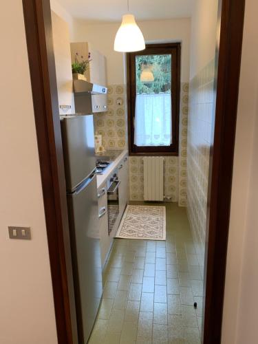 Elle comprend une petite cuisine avec un réfrigérateur et une fenêtre. dans l'établissement Bilocale Sorgente, à Ponte di Legno